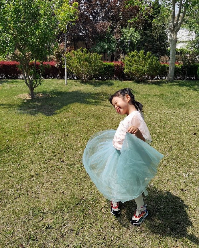 包文婧分享女儿春日萌照 饺子穿纱裙草坪玩耍俏皮可爱