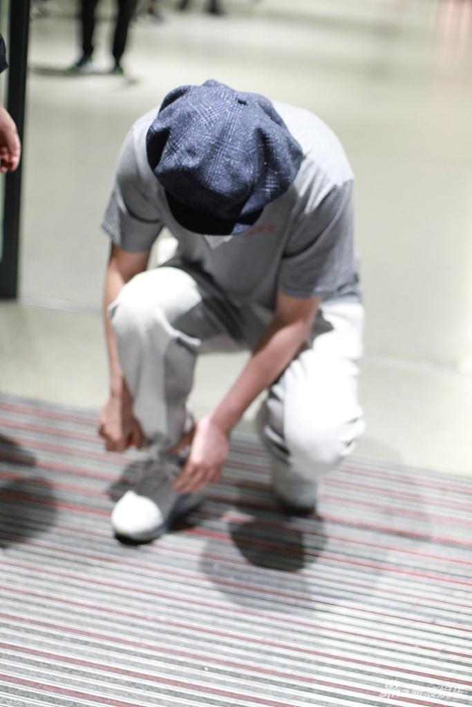 雷佳音戴画家帽蹲地系鞋带 为粉丝签名十分亲和