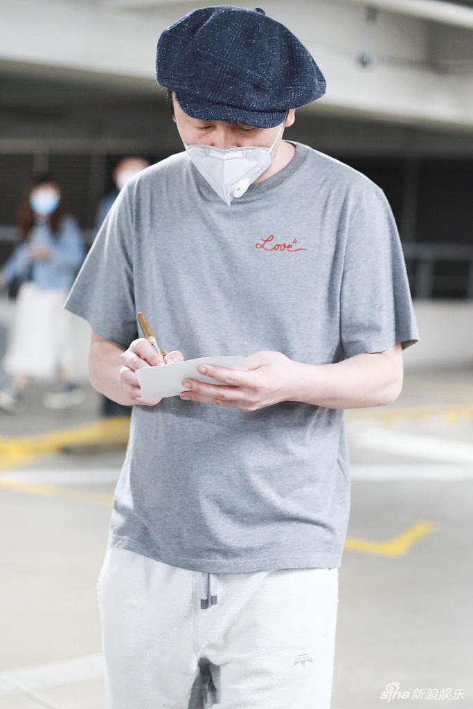 雷佳音戴画家帽蹲地系鞋带 为粉丝签名十分亲和