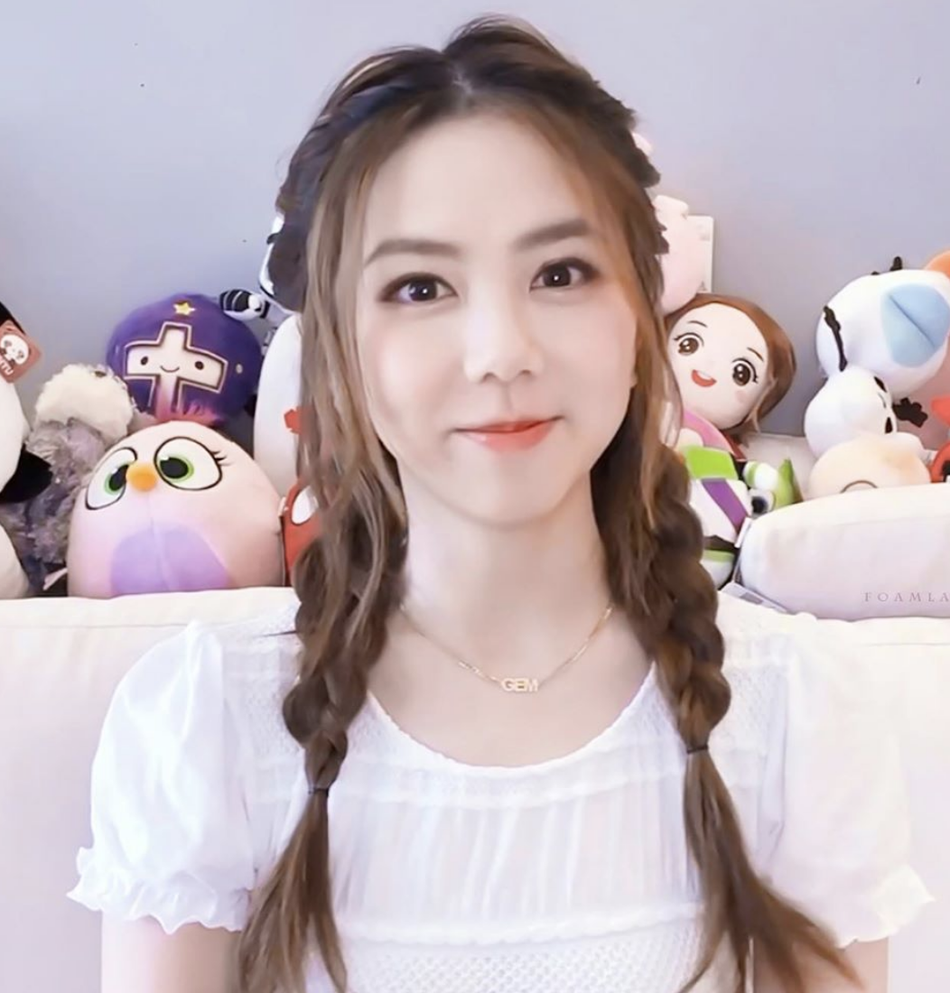 邓紫棋扎双麻花辫甜笑少女感足 身后娃娃堆抢镜