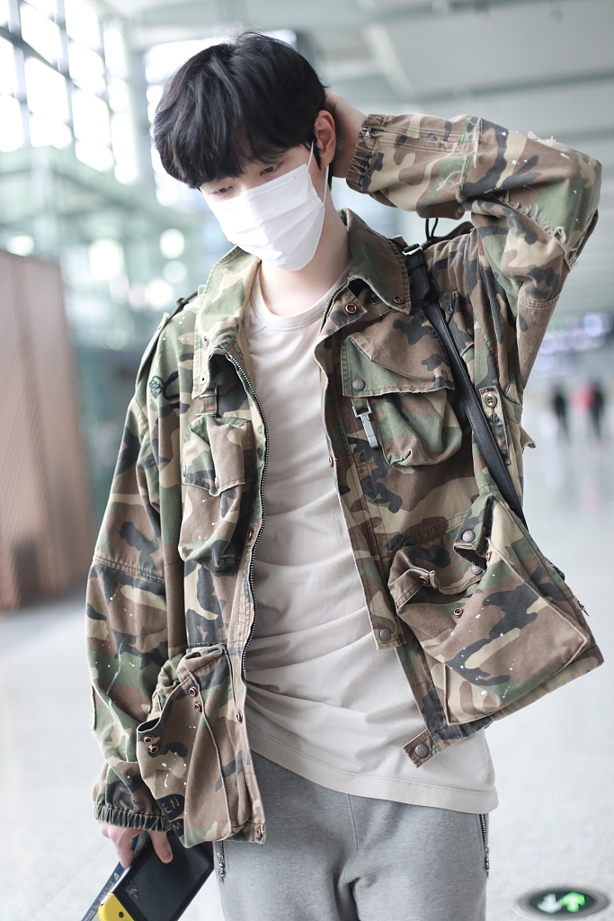 王喆穿迷彩外套低调有型 手推行李箱迈大步秀长腿