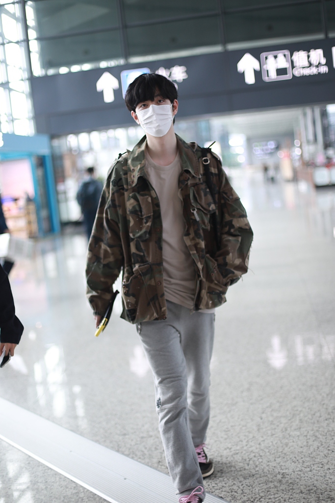 王喆穿迷彩外套低调有型 手推行李箱迈大步秀长腿