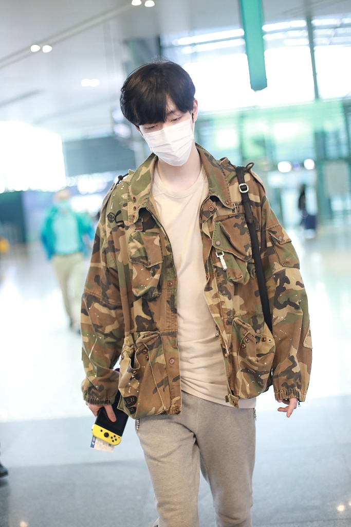 王喆穿迷彩外套低调有型 手推行李箱迈大步秀长腿