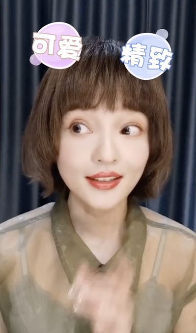 张韶涵栗色短卷发干净利落 穿绿色薄纱上衣皮肤白皙