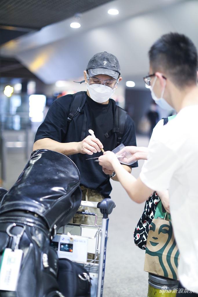 吴奇隆推一车行李腾出手打招呼 大方送粉丝签名