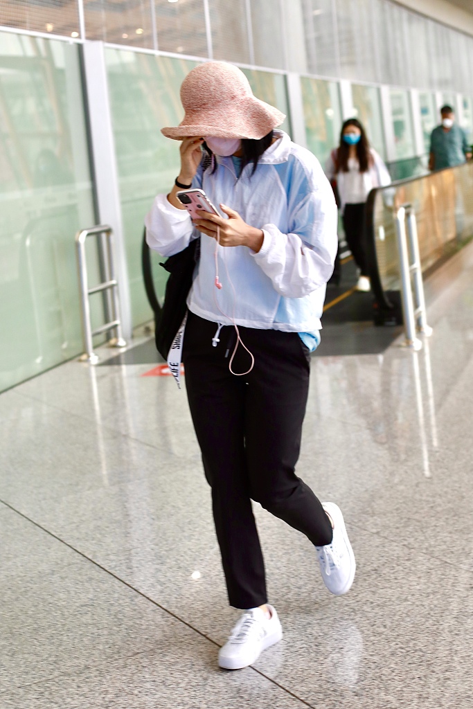 胡可赶路一身轻松玩手机 着休闲服干练戴粉嫩帽子