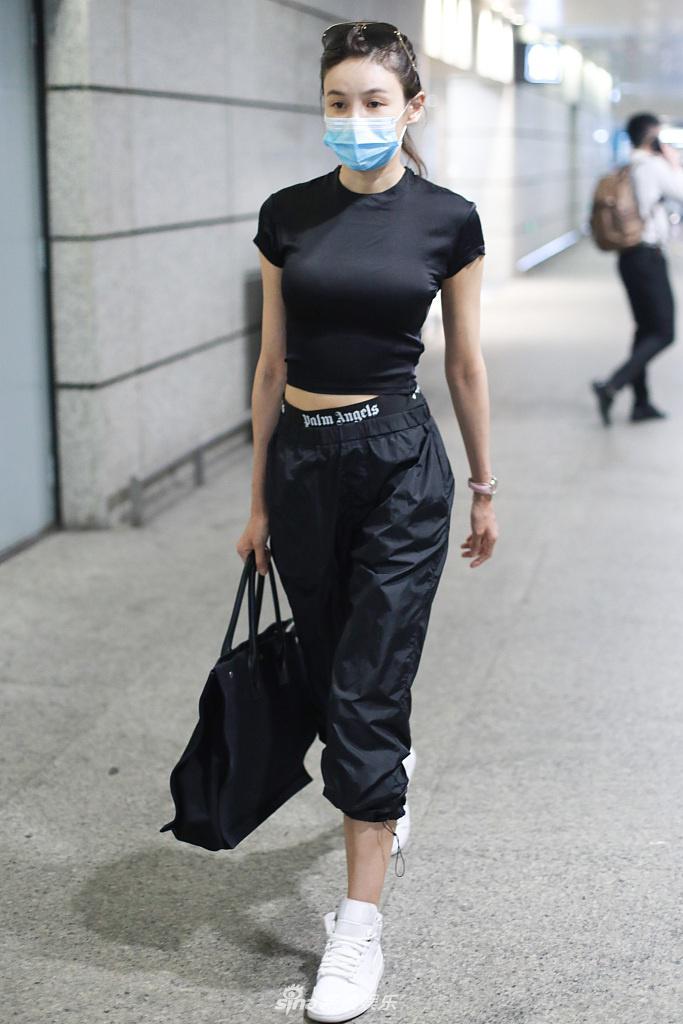 张蓝心穿黑色紧身衣小露蛮腰 皮肤白皙透亮拎包气质飒爽