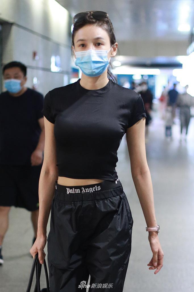 张蓝心穿黑色紧身衣小露蛮腰 皮肤白皙透亮拎包气质飒爽