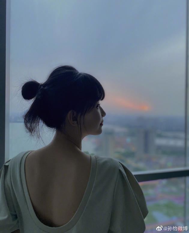 孙怡晒照纪念第900条微博 夕阳下站窗边大秀美背