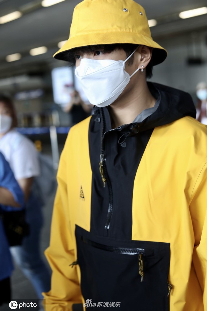 UNINE李汶翰现身机场 亮黄色外套十分抢眼