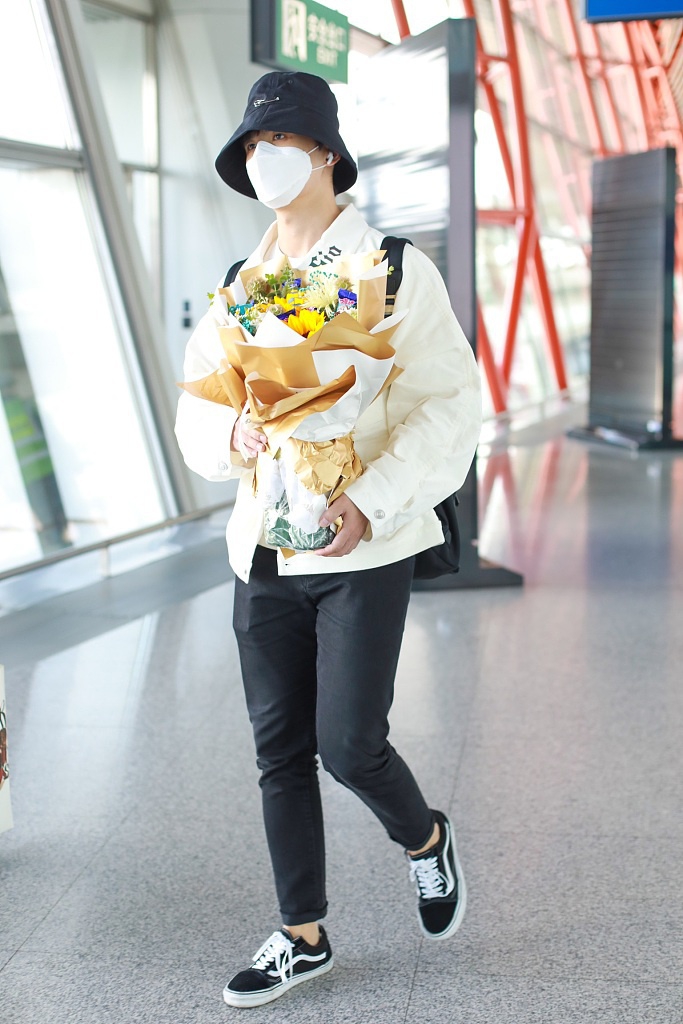 张远戴渔夫帽抱花束低调疾走 极简黑白穿搭清爽有型