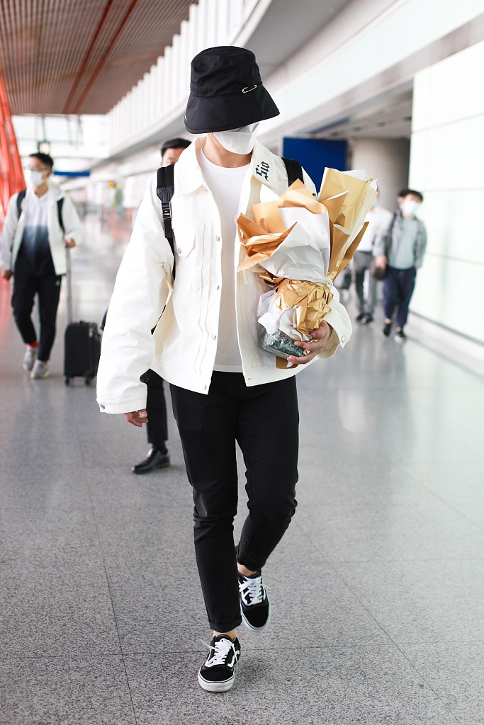 张远戴渔夫帽抱花束低调疾走 极简黑白穿搭清爽有型