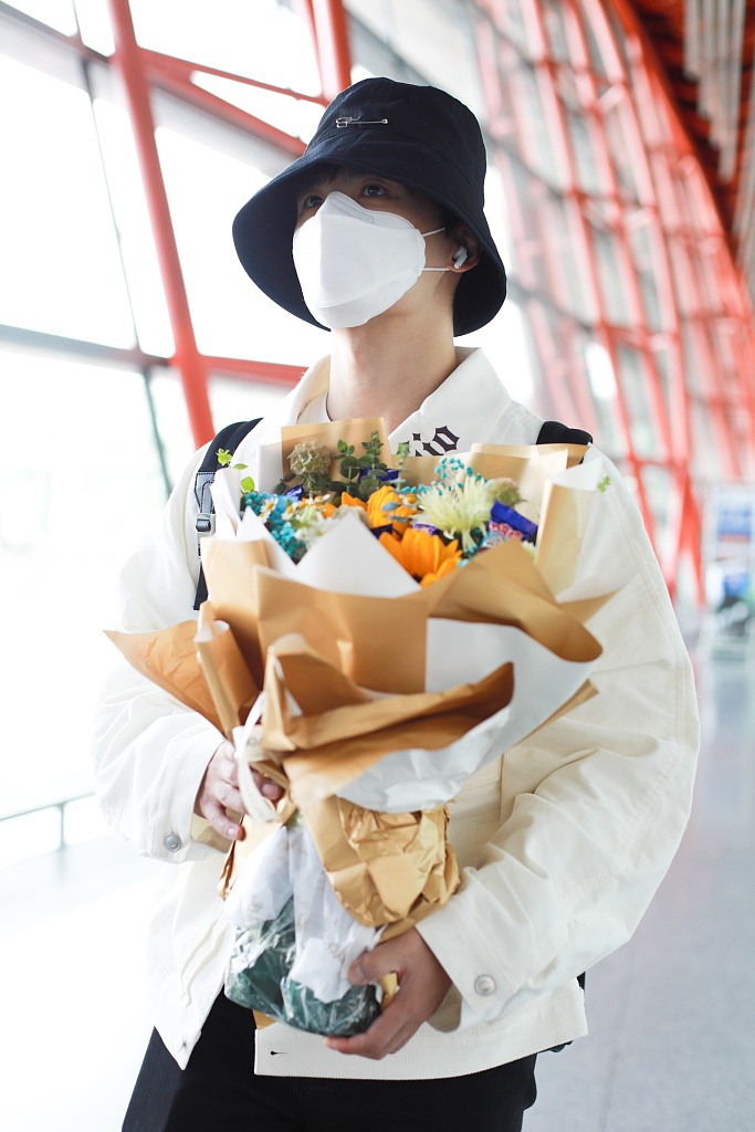 张远戴渔夫帽抱花束低调疾走 极简黑白穿搭清爽有型