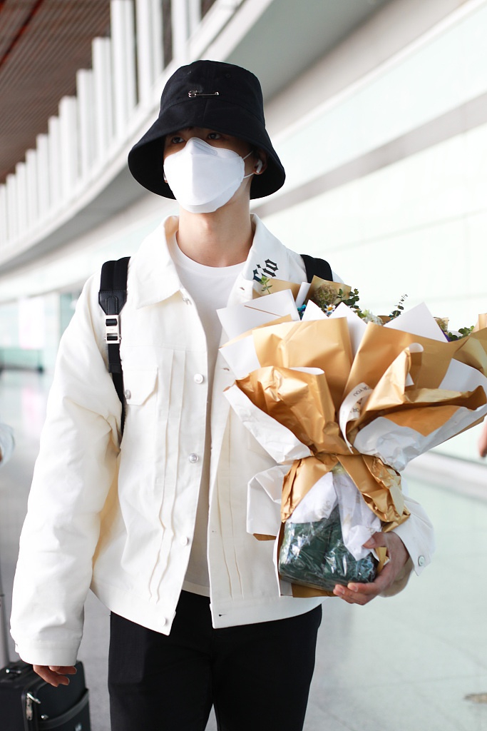 张远戴渔夫帽抱花束低调疾走 极简黑白穿搭清爽有型