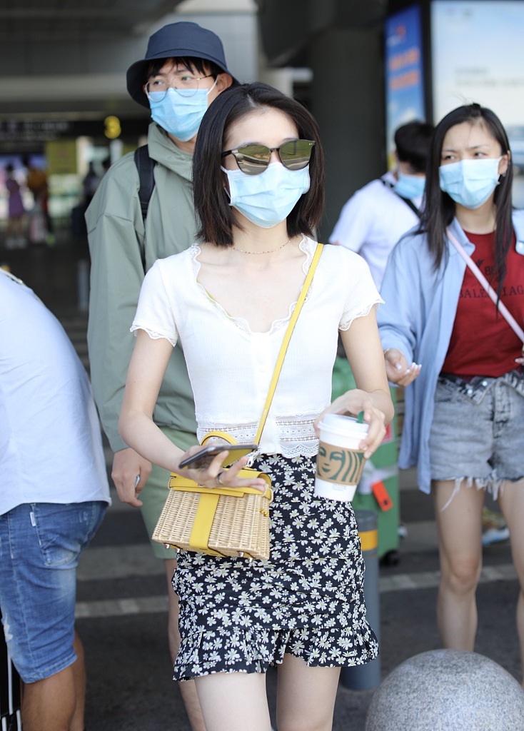 张雪迎穿白色上衣搭短裙现身机场 一路捣鼓竹篮包超吸睛