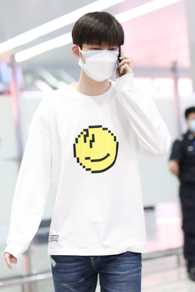 董力穿白色笑脸T恤走机场 表情认真身高引人瞩目