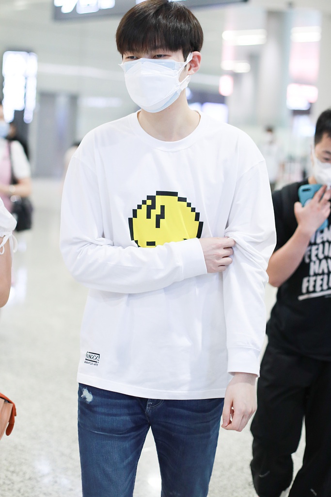 董力穿白色笑脸T恤走机场 表情认真身高引人瞩目