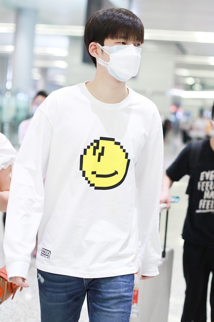 董力穿白色笑脸T恤走机场 表情认真身高引人瞩目