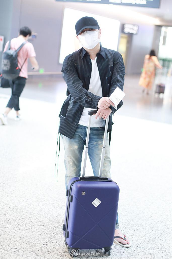 沈腾踩人字拖遛机场不拘小节  坐行李箱歇脚十分随性