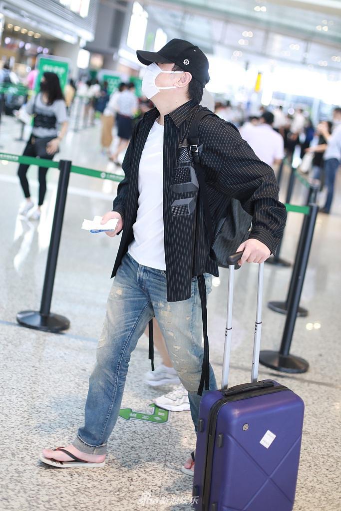 沈腾踩人字拖遛机场不拘小节  坐行李箱歇脚十分随性