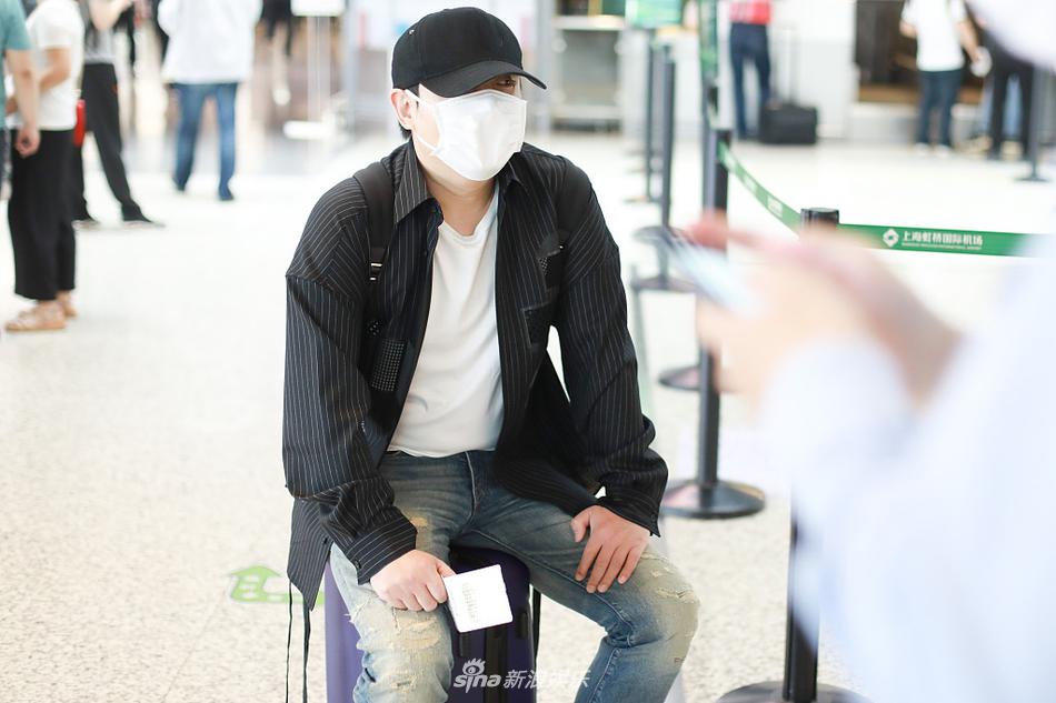 沈腾踩人字拖遛机场不拘小节  坐行李箱歇脚十分随性