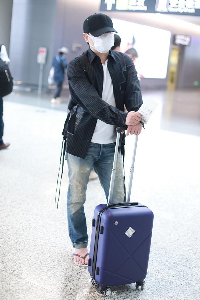 沈腾踩人字拖遛机场不拘小节  坐行李箱歇脚十分随性