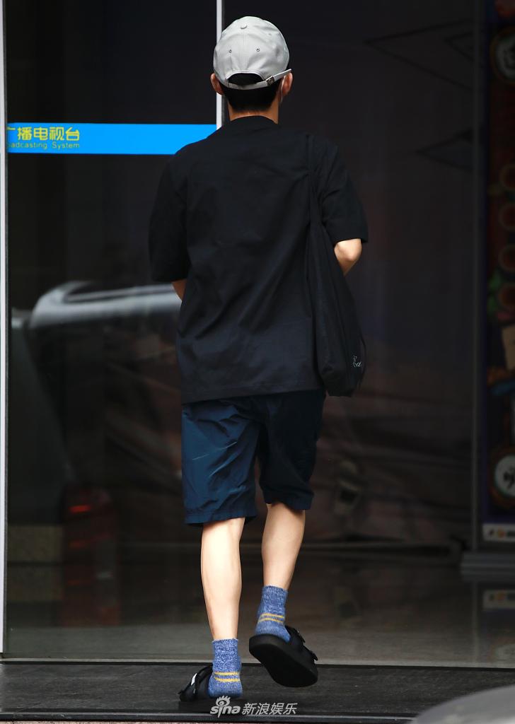 何炅穿棉袜脚踩拖鞋现身录制 装扮简约随性一路小跑