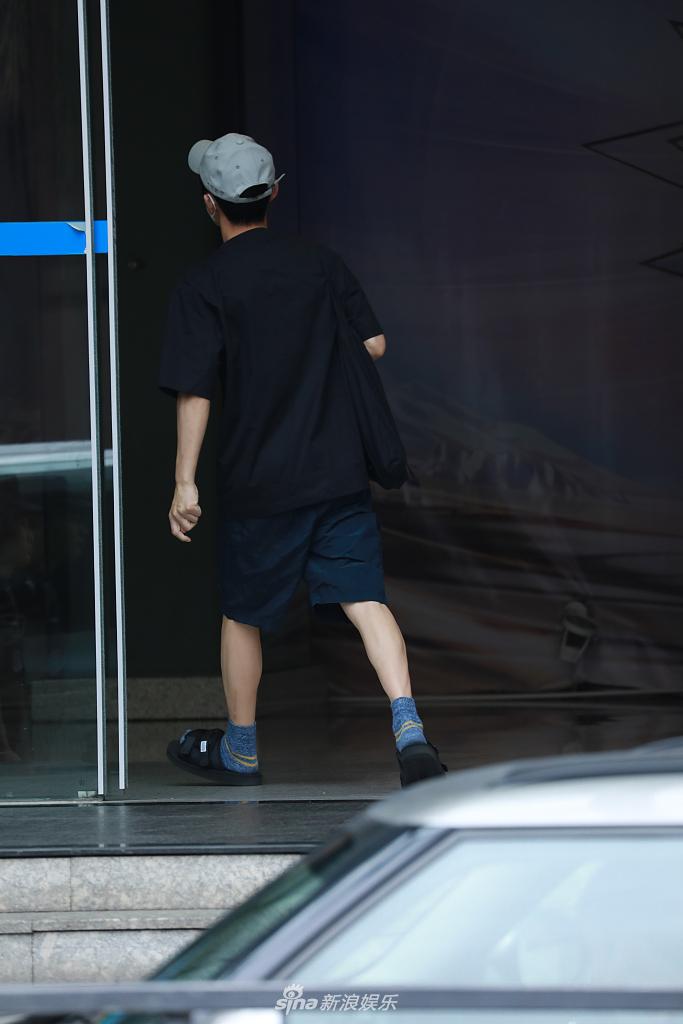 何炅穿棉袜脚踩拖鞋现身录制 装扮简约随性一路小跑