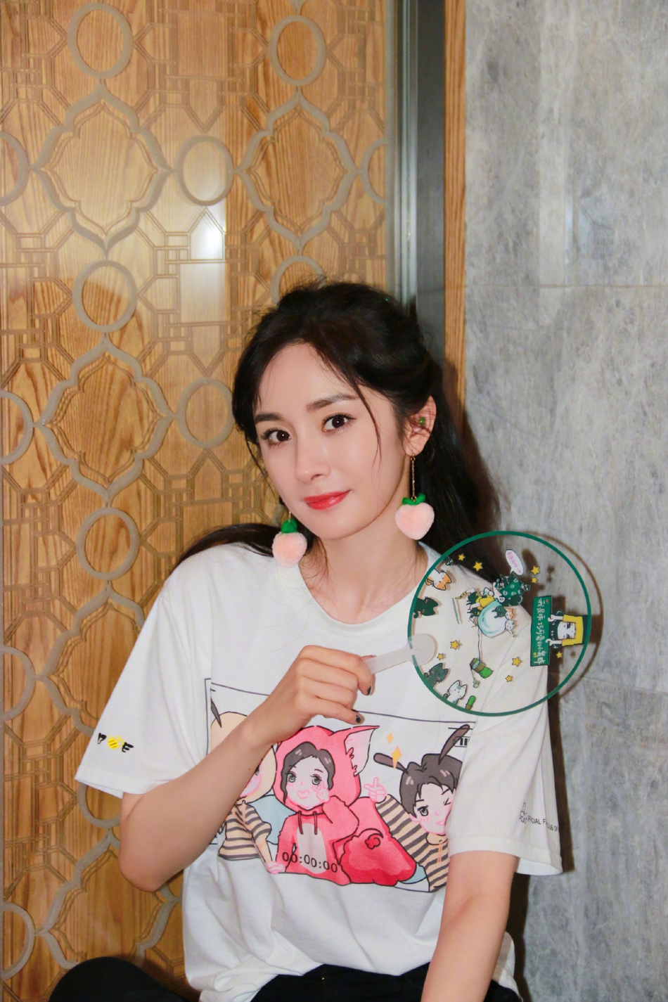 杨幂穿粉丝团会服拿透扇 蜜桃耳坠时尚抢眼