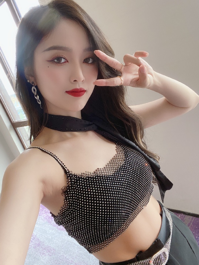 吴宣仪分享十六宫格美照 穿露腰上衣配黑领带气场十足