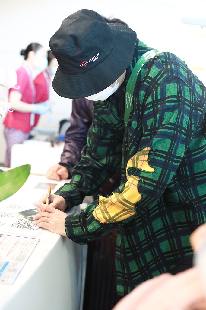 秦昊装扮休闲现身机场 “一起爬山么”手机壳抢镜