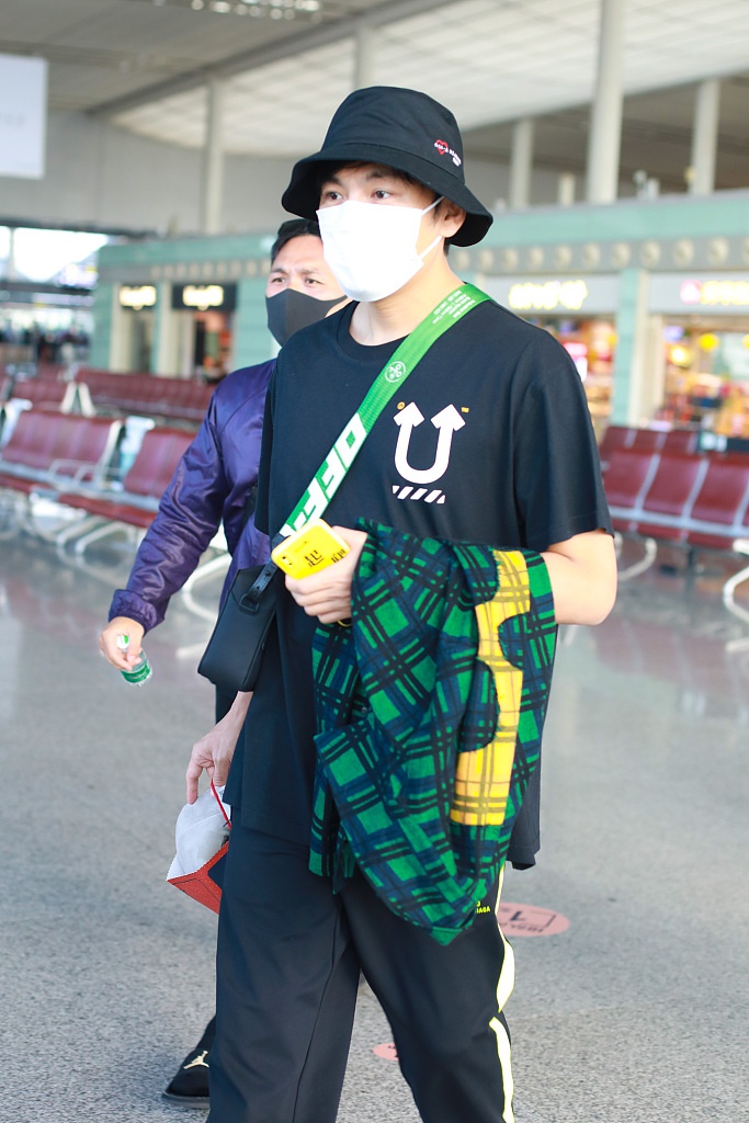 秦昊装扮休闲现身机场 “一起爬山么”手机壳抢镜