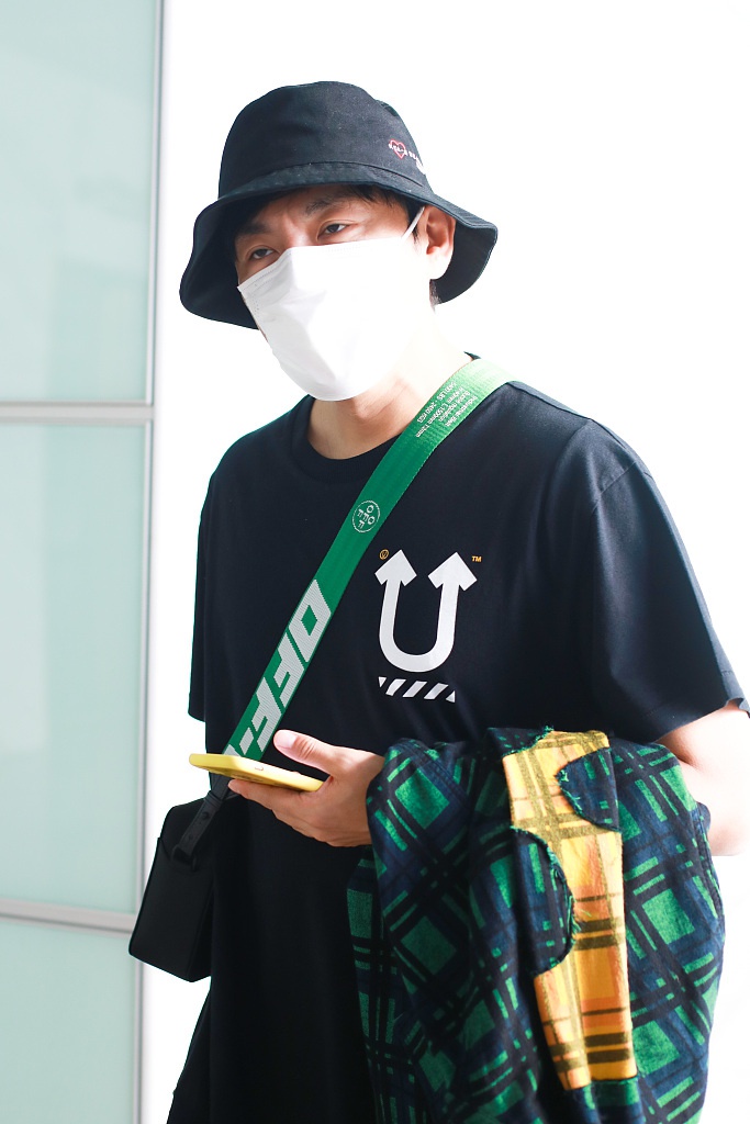 秦昊装扮休闲现身机场 “一起爬山么”手机壳抢镜