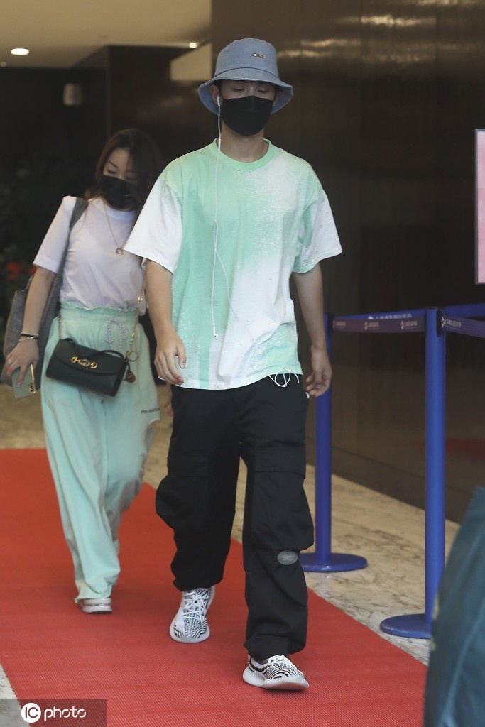 黄明昊穿淡绿色T恤出街 大步流星难掩帅气