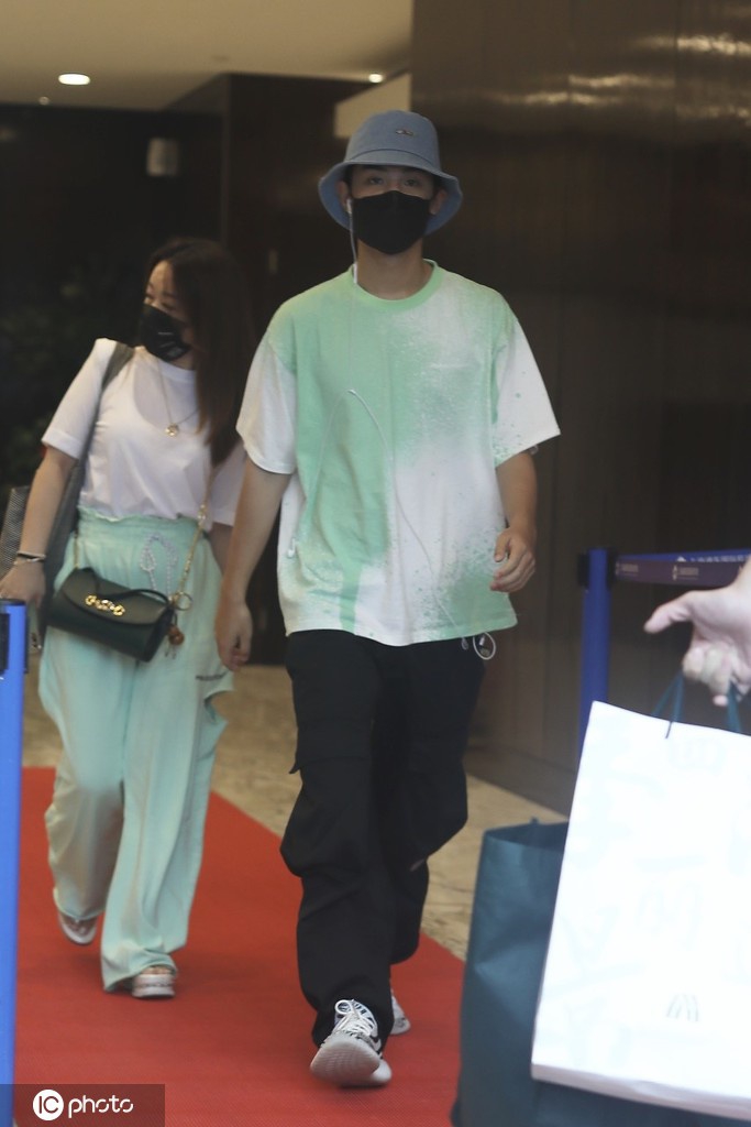 黄明昊穿淡绿色T恤出街 大步流星难掩帅气