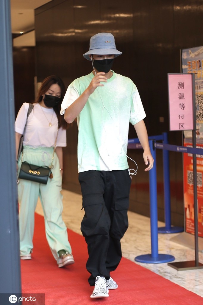黄明昊穿淡绿色T恤出街 大步流星难掩帅气