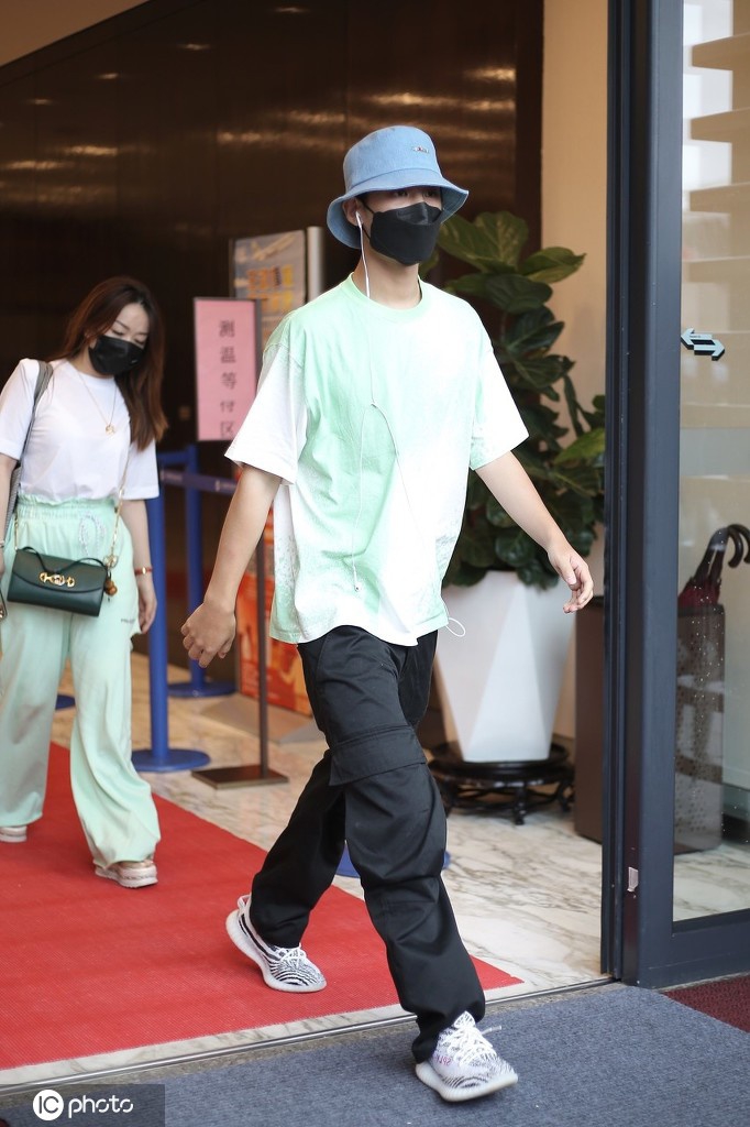 黄明昊穿淡绿色T恤出街 大步流星难掩帅气