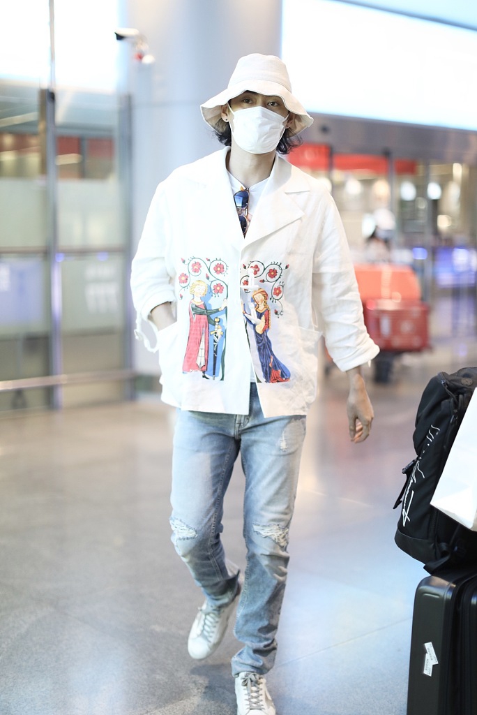 袁弘穿印花上衣造型别致 戴白色渔夫帽对镜挥手