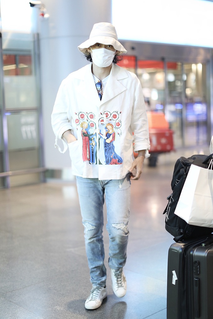 袁弘穿印花上衣造型别致 戴白色渔夫帽对镜挥手