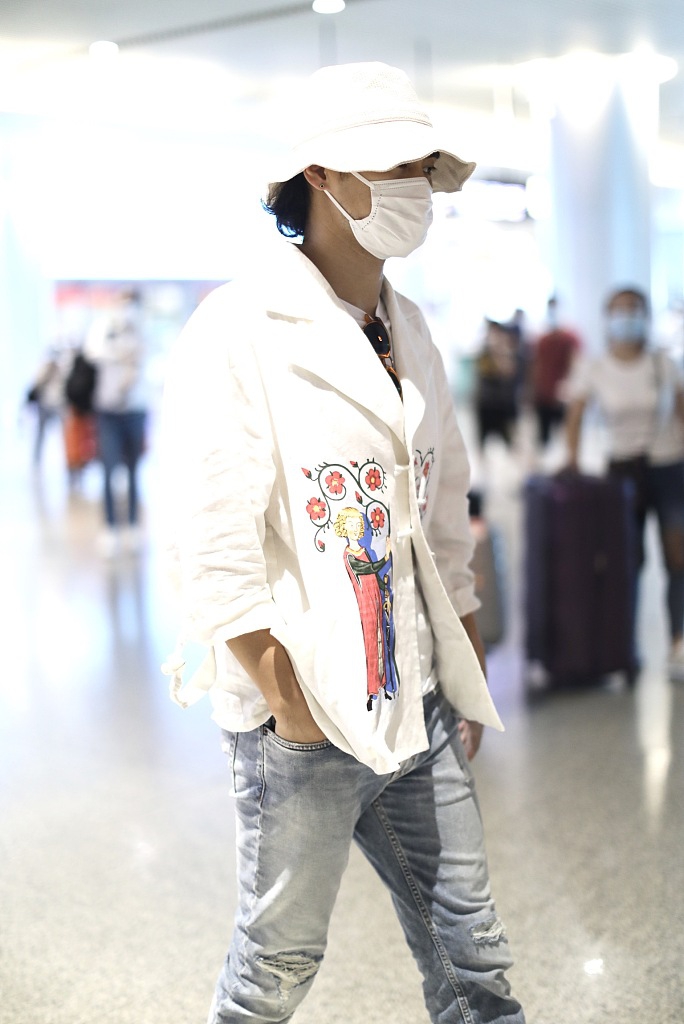 袁弘穿印花上衣造型别致 戴白色渔夫帽对镜挥手