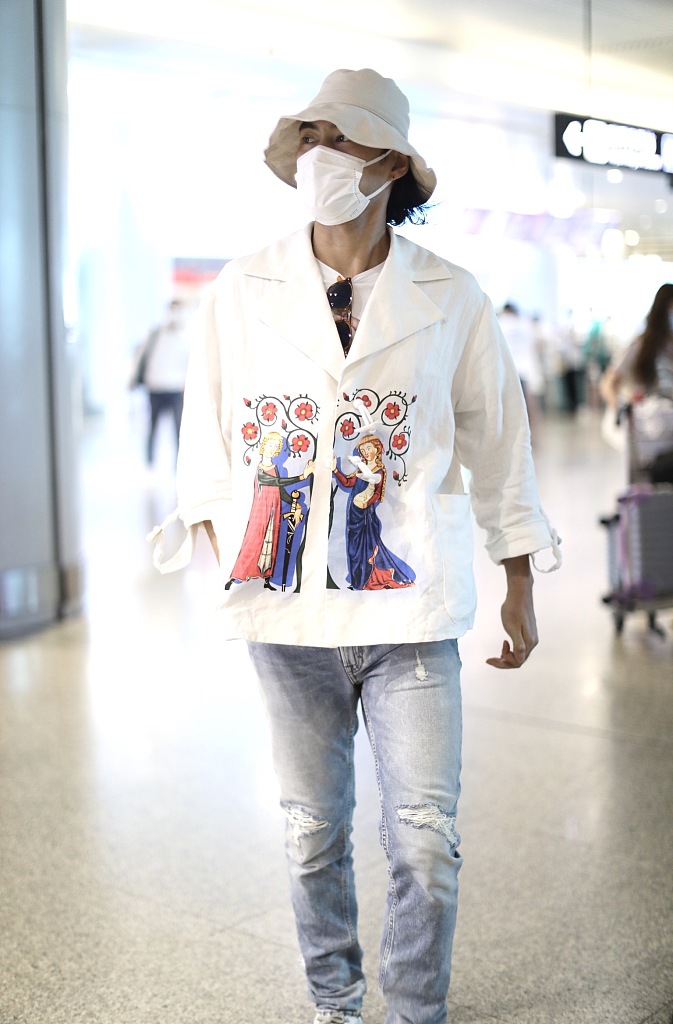 袁弘穿印花上衣造型别致 戴白色渔夫帽对镜挥手