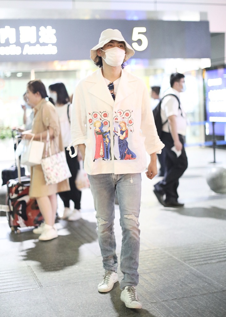 袁弘穿印花上衣造型别致 戴白色渔夫帽对镜挥手