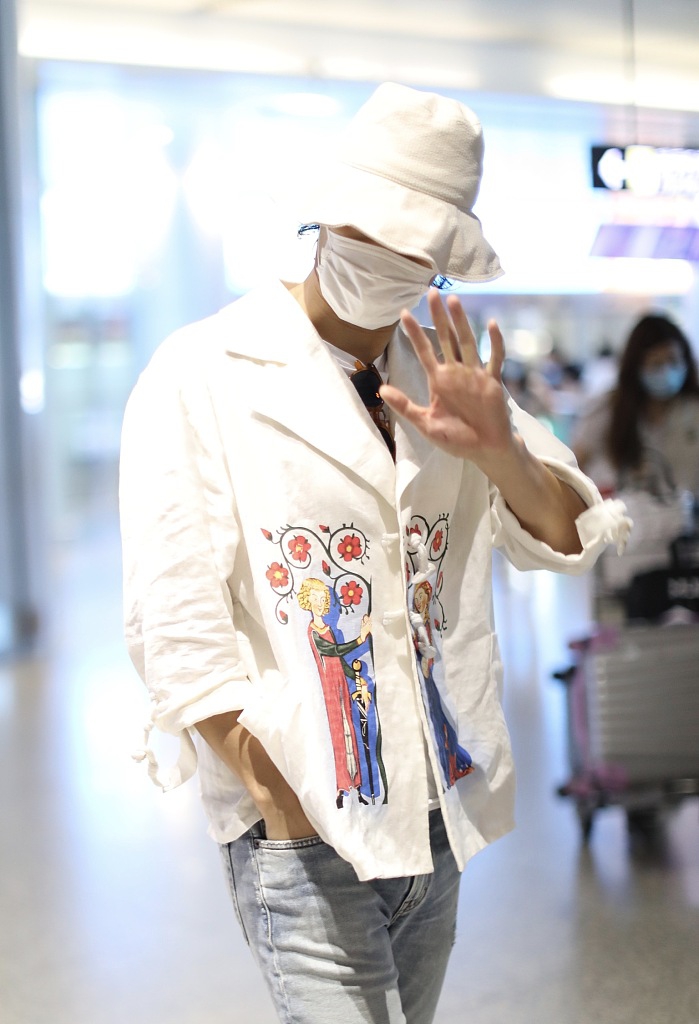 袁弘穿印花上衣造型别致 戴白色渔夫帽对镜挥手