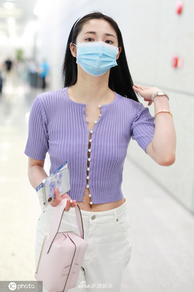 周洁琼穿香芋紫短T现身机场 温婉妩媚小秀性感