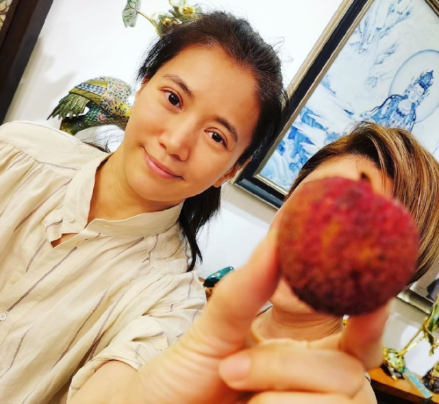 袁咏仪素颜与好友合照 拿荔枝遮脸甜笑超自信