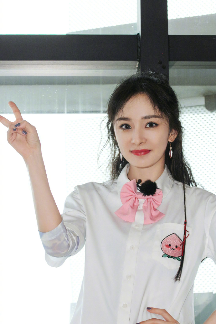 杨幂梳双马尾戴粉色领结 对镜比剪刀手少女感满满
