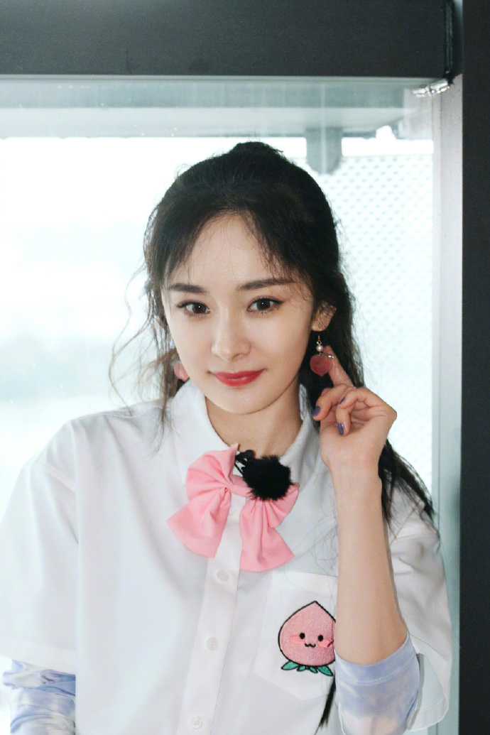 杨幂梳双马尾戴粉色领结 对镜比剪刀手少女感满满