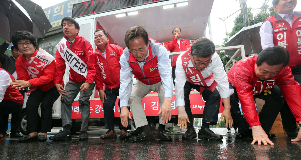 韩国首尔市长候选人冒雨跪地拉票
