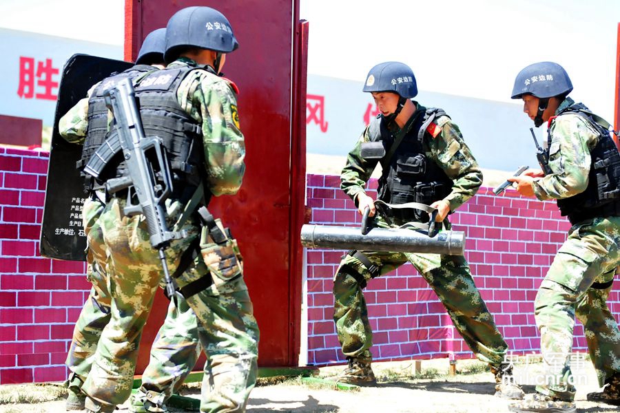 突击组队员正用黑鹰破门工具破门突入