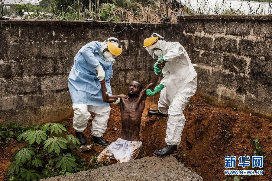 治疗中心拍摄的医护人员将因埃博拉病毒导致癫狂的患者带回隔离病房
